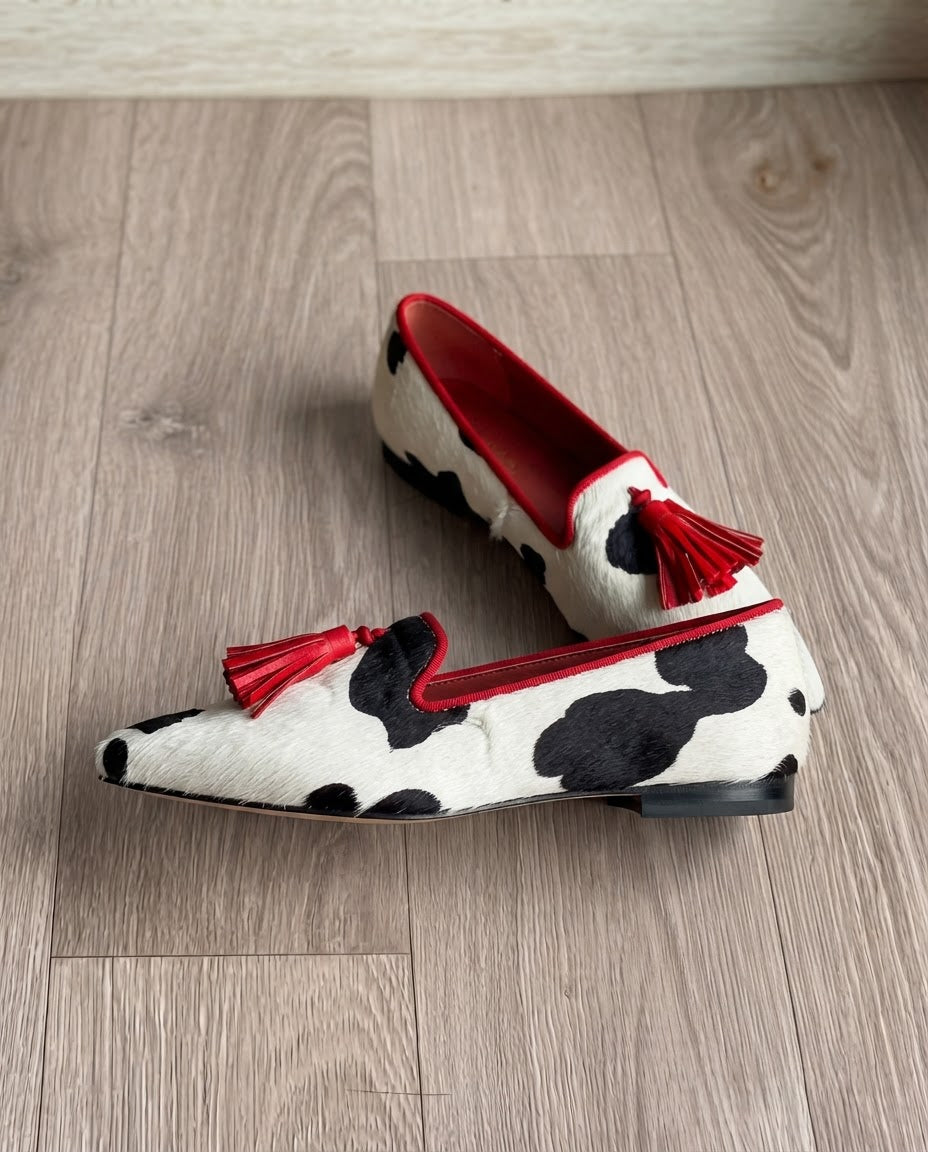 Violeta | Mocasines de Punta Fina con Estampado de Vaca y Borlas Rojas
