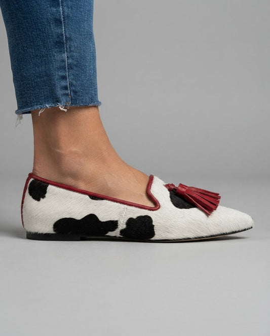 Violeta | Mocasines de Punta Fina con Estampado de Vaca y Borlas Rojas