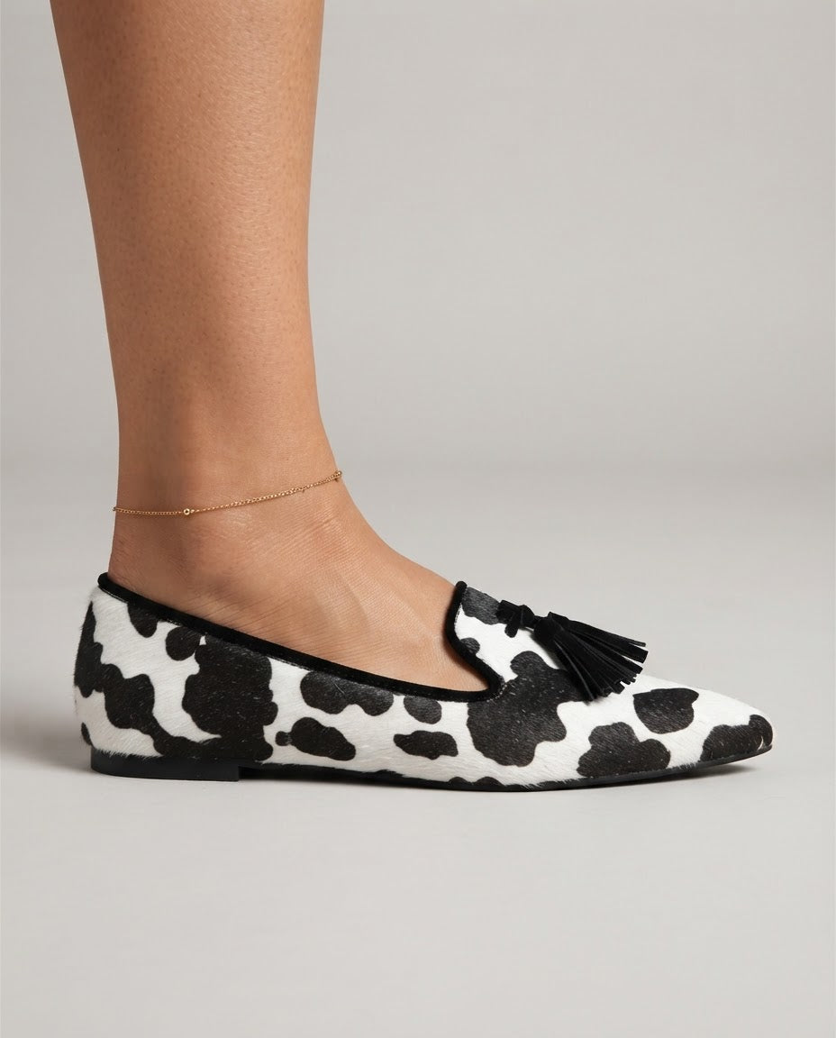 Valentina | Mocasines de Punta Fina con Estampado de Vaca y Borlas Negras