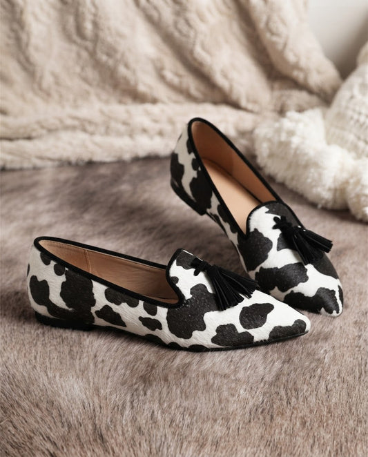 Valentina | Mocasines de Punta Fina con Estampado de Vaca y Borlas Negras